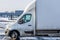 White parked van during winter with a warehouse in the background, logistics and transportation vehicle