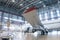 White passenger aircraft in the aviation hangar. Airplane under maintenance