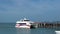 White passenger catamaran arriving to wooden pier, Samui, Thailand - 5 June 2017