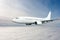 White passenger jetliner flying in the air above the clouds