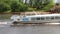 White passenger ship sails on river at sunny summer day