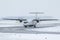 White passenger turboprop airplane taxiing on the taxiway in a severe blizzard