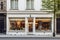 White pastry shop cafe facade with large window showcasing interior, city setting.