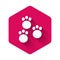 White Paw print icon isolated with long shadow. Dog or cat paw print. Animal track. Pink hexagon button. Vector