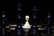 White pawn standing alone in spotlight on chess board with black