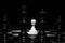 White pawn standing alone in spotlight on chess board with black