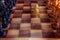 White pawn staying against full set of black chess pieces. Closeup of chessboard with wooden pieces on table in sunlight, game of