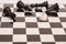 White pawn surrounded by black chess pieces