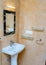 White pedestal washbasin and black-framed mirror - bathroom interior