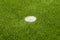 The white penalty point on the artificial green grass soccer field