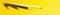 A white pencil that stands out from the crowd of many identical black counterparts on a yellow background. Leadership, uniqueness