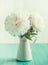 White peonies in floral vase on wooden table, vintage mint colors