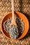 White pepper on wooden spoon in earthen bowl, most important flavourings in East Asia