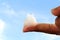 White petroleum jelly on finger in sky background