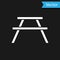 White Picnic table with benches on either side of the table icon isolated on black background. Vector Illustration