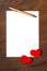 White piece of paper for pasting text, hearts and pen on wooden background, vertical format. Workpiece for design, copy space