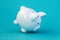 White piggy bank falling on blue background