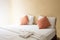 white pillow and orange pillow on bed and with blanket in vintage bedroom with lighting in morning