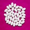 White pills group on magenta background