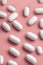 White Pills Scattered on Pastel Background