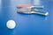 White ping-pong ball with rackets on background