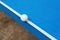 White pingpong ball hits the edge of blue pingpong table