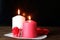 White and pink burning aromatic candles, roses, gift on white openwork paper napkin on wooden table, selective focus. Love,