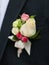 White and pink rose wedding boutonniere on suit