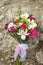 White and pink wedding bouquet on a rock background