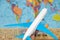 White plane with blue wings on the background of the atlas of the world. The concept of travel around the world