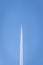 White plane soaring through a clear blue sky leaving behind a trail