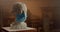 White plaster bust of famous person wearing medical mask standing on small table in sculptor studio. Conept of art on