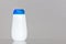 White plastic bottle with a blue cap for cosmetic or hygienic detergents with space for a logo or brand. On a wooden table on a