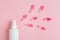 White plastic bottle of floral facial moisturizing toner or rose hair spray  and petals isolated on pastel pink background