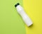 White plastic bottle for milk on a green background, container for liquid products