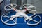 White plastic flying drone with four propellers company DJI