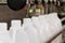 White plastic gallons or bottles on the production line of the conveyor at filling machine in the factory. selective focus.