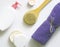 White plastic jars with creams, purple towel, candle, brush for dry massage. The concept of Spa, body care. Top view.