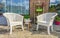 White plastic lounge chairs with a small wooden table and garden decorations in the backyard at home