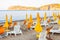 White plastic and metal construction with yellow fabric deckchairs together with yellow umbrellas on the sand beach of Tyrrhenian