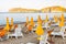 White plastic and metal construction with yellow fabric deckchairs together with yellow umbrellas on the sand beach of Tyrrhenian