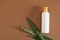 white plastic mock-up blank bottle for cosmetics and sansevieria leaves