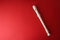 White plastic recorder on red gradient background