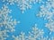 White plastic snowflakes  on a blue background.