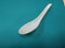 white plastic spoon surrounded by green background