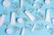 White plastic tubes, jars, and gypsophila branches on a blue background, containers for cosmetic creams and gels, advertising and