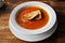 White plate of appetizing tomato soup with fresh