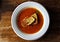 White plate of appetizing tomato soup with fresh