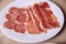 White plate with assorted cured meats including salami and prosciutto