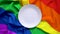 White plate on the background of the LGBT symbol rainbow close-up.